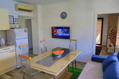 a kitchen with a table with a bowl of watermelon on it at Holiday Homes Pozitiva in Bihać
