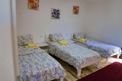 a room with three beds and a couch at Holiday Homes Pozitiva in Bihać