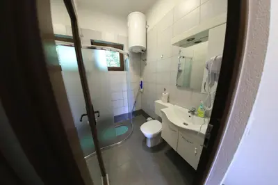a bathroom with a toilet and a sink and a mirror at Holiday Homes Pozitiva in Bihać