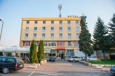 a large building with cars parked in a parking lot at Prenoćište 