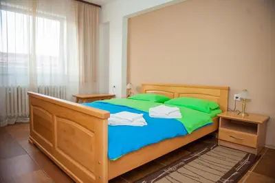 a bedroom with a large wooden bed with green pillows at Prenoćište 