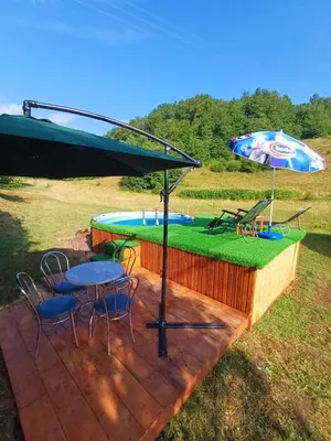 a patio with a table and chairs and an umbrella at Apartman Denis Una in Lužine