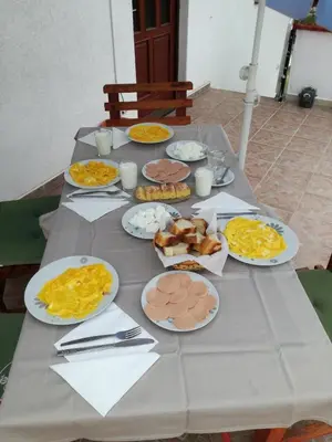 a table with many plates of food on it at Apartman Denis Una in Lužine