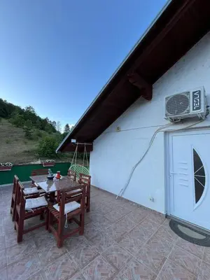 a patio with a table and a air conditioner on a building at Apartman Denis Una in Lužine