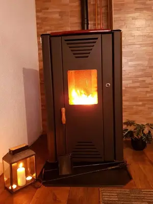 a stove with a fire in a room with two candles at Vikend Kuća Iman in Vlasic