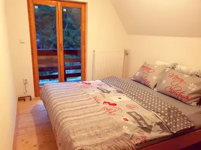 a bed in a small room with a window at Vikend Kuća Iman in Vlasic