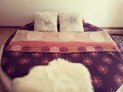 a bed with pillows and a white rug on it at Vikend Kuća Iman in Vlasic