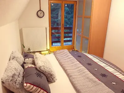 a bedroom with a bed with pillows and a clock at Vikend Kuća Iman in Vlasic