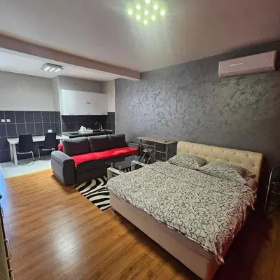 a bedroom with a bed and a living room at Apartment Savanovic in Banja Luka