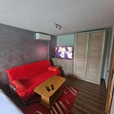 a living room with a red couch and a tv at Apartment Savanovic in Banja Luka