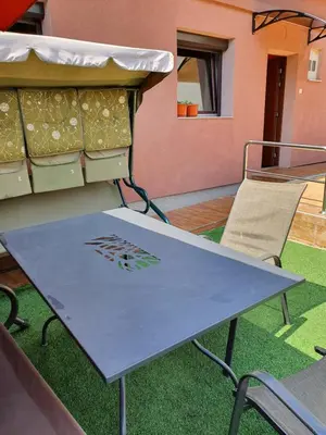 a ping pong table and a chair on a patio at Apartment Savanovic in Banja Luka