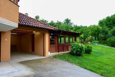 a house with a garage and a grass yard at Holiday Home Pharaoh in Visoko