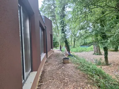 a side view of a building with a window and trees at Farah Superior Apartments in Bihać