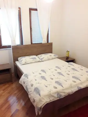 a bedroom with a bed with a white comforter at Farah Superior Apartments in Bihać