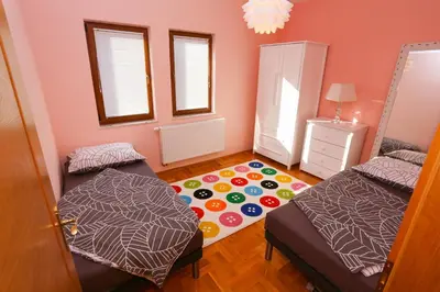 a bedroom with two beds and a rug at Farah Superior Apartments in Bihać