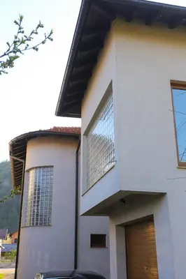 a white house with a window and a door at Farah Superior Apartments in Bihać