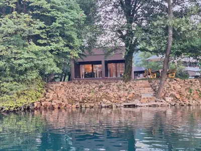 a house on a rock wall next to a body of water at Farah Superior Apartments in Bihać