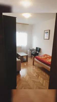 a bedroom with a bed and a living room at Apartments Konak in Visoko