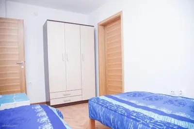 a bedroom with two beds and a white cabinet at Apartments Konak in Visoko
