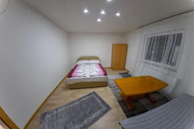 a small bedroom with a bed and a table at Apartments Aqua Resa in Bihać