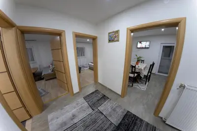 a hallway with two doors and a room with a table at Apartments Aqua Resa in Bihać
