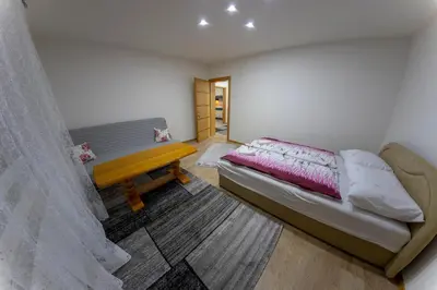 a bedroom with a bed and a wooden table at Apartments Aqua Resa in Bihać