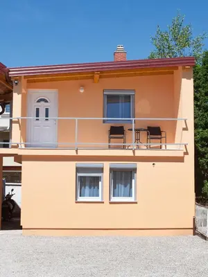 a orange house with chairs on the balcony at Apartments Aqua Resa in Bihać