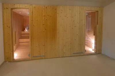 a room with three wooden doors in a room at Hotel Rekic in Bihać
