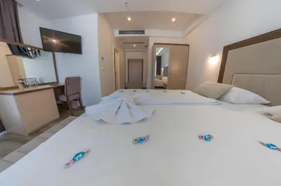 a bedroom with a large white bed with decorations on it at Hotel Rekic in Bihać