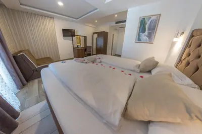 a bedroom with two beds with red decorations on them at Hotel Rekic in Bihać