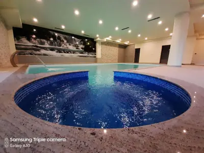 a large pool with blue water in a room at Hotel Rekic in Bihać