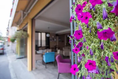 a plant with pink flowers on the side of a building at Heartland City B&B in Tuzla