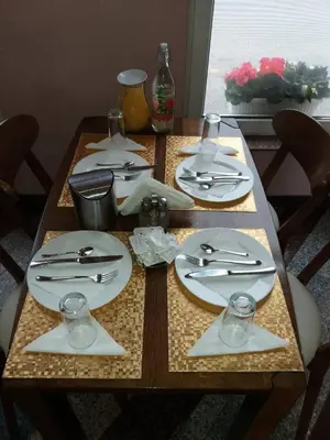 a wooden table with plates and silverware on it at Nihad B&B in Visoko