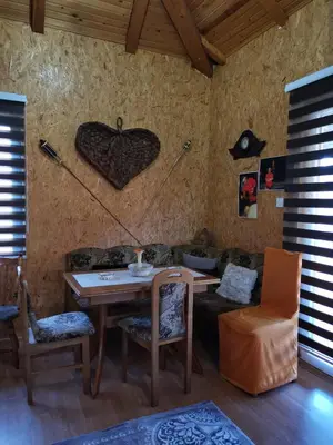 a living room with a table and a couch at Forest Lodge on the Pyramid in Visoko