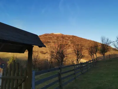 a fence in front of a hill with a mountain at Forest Lodge on the Pyramid in Visoko