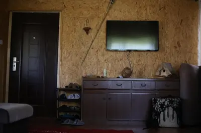 a living room with a television on a wall at Forest Lodge on the Pyramid in Visoko