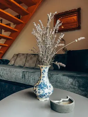 a blue and white vase with flowers on a table at Holiday Home Amila in Visoko