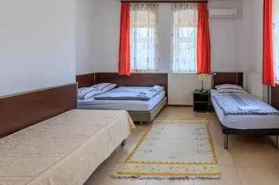 two beds in a room with red curtains at Apartments Villa Kobilj in Banja Luka