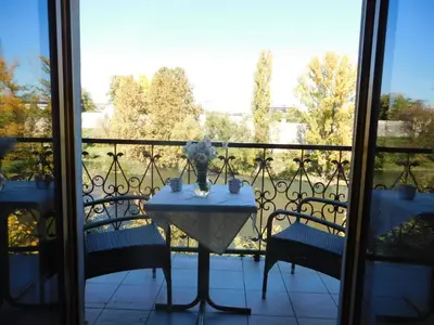 a table with a vase of flowers on a balcony at Apartments Villa Kobilj in Banja Luka