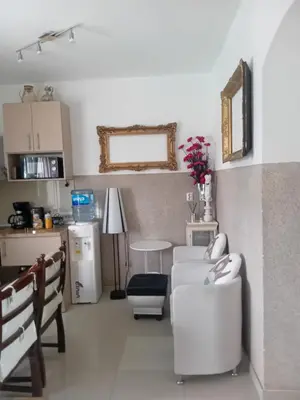 a living room with a white couch and a kitchen at Apartment Top Centar in Banja Luka