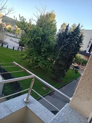 a metal railing on a balcony with a tree at Apartment Top Centar in Banja Luka