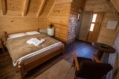a bedroom with a bed in a log cabin at Hotel Babino Brdo in Derventa