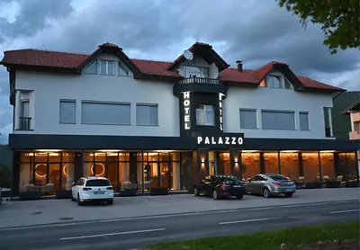 a building with cars parked in front of it at Hotel Palazzo in Gornji Vakuf