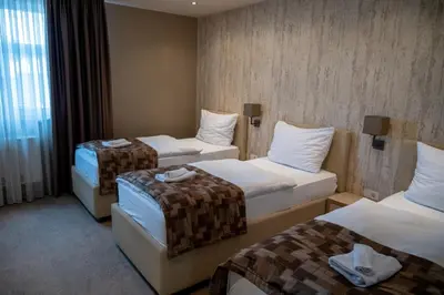 a hotel room with three beds with towels on them at Hotel Palazzo in Gornji Vakuf
