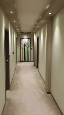 an empty hallway with a painting of trees on the wall at Hotel Palazzo in Gornji Vakuf