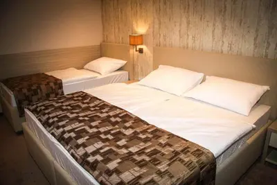 two beds in a hotel room with two bedsvisor at Hotel Palazzo in Gornji Vakuf