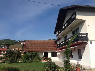 a white building with a red roof at Apartments Kenedy in Kiseljak