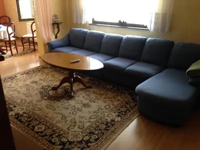 a living room with a blue couch and a table at Apartments Kenedy in Kiseljak