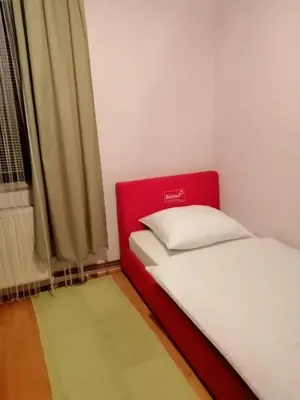 a bedroom with two beds with a red headboard at Apartments Kenedy in Kiseljak