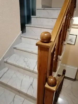 a white marble staircase with two gold spheres on it at Apartments Kenedy in Kiseljak